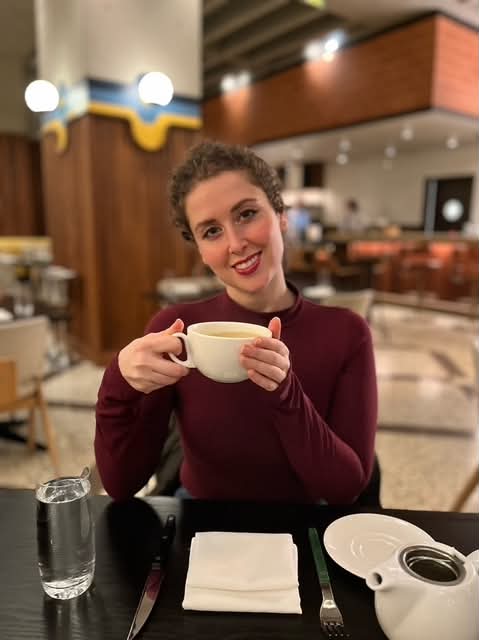 Kirsten smiling over a warm cup of tea